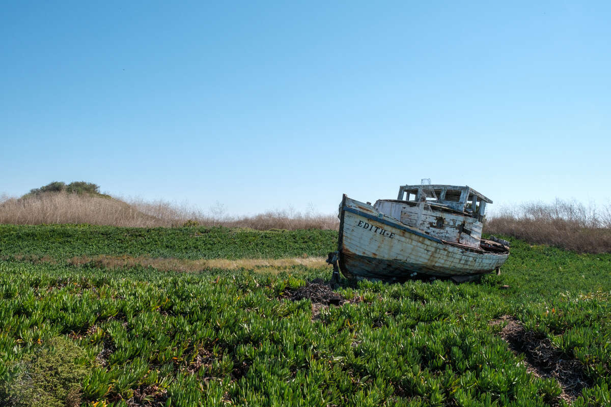 a large, old boat aground in a field