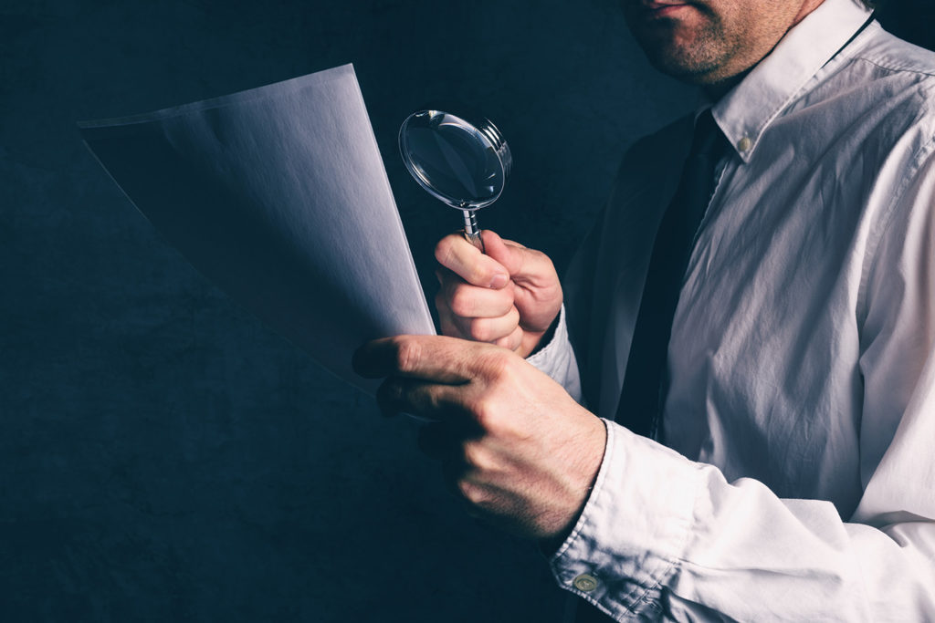 lawyer examining document with magnifying glass