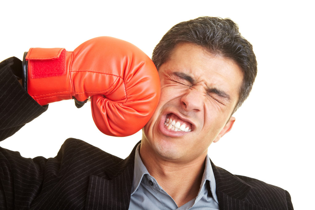 attorney wearing a boxing glove, punching himself in the cheek