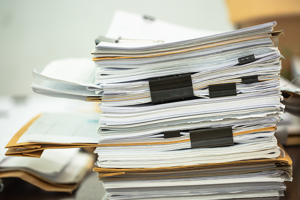 thick binders stacked on a desk