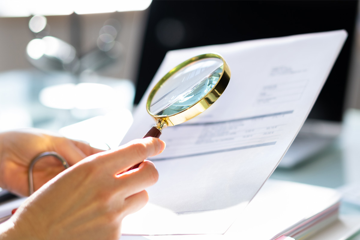 examing a document with a magnifying glass