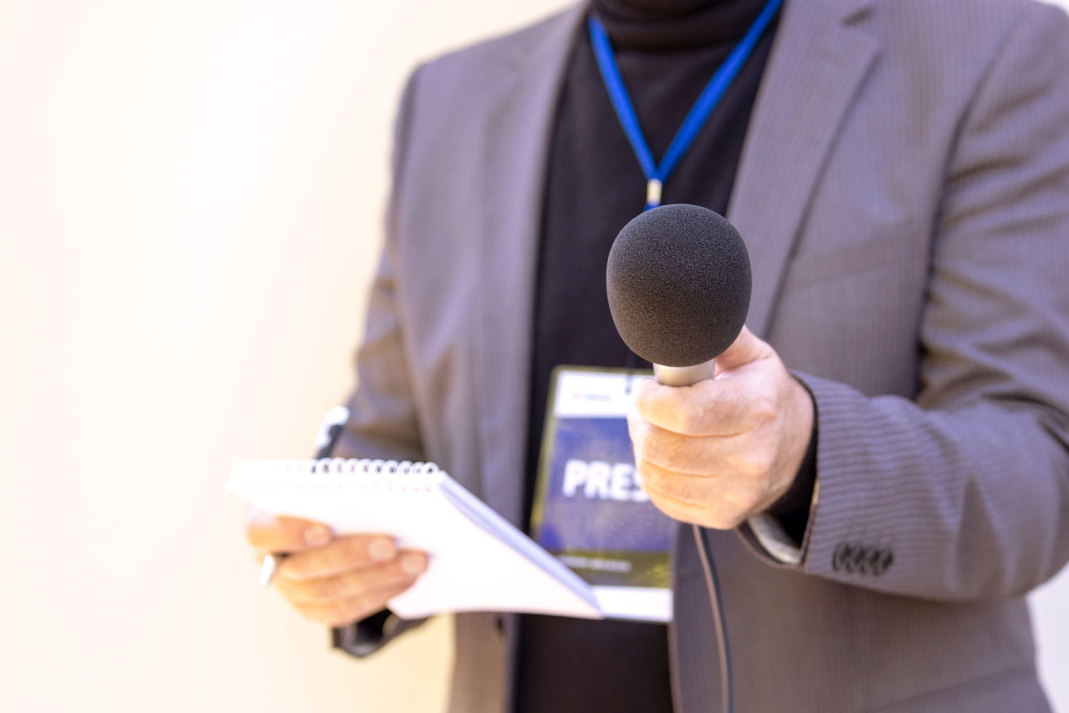 reporter holding a notepad and microphone