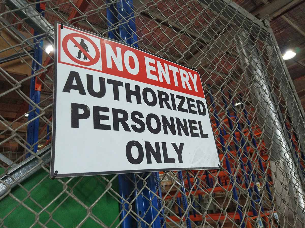 Authorized Personnel Only sign on a chain link fence
