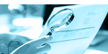 hand examining a document with a magnifying glass