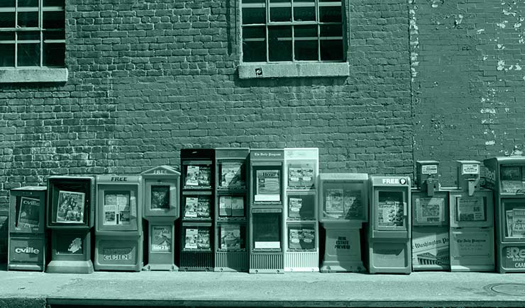 Newspaper machines along a wall