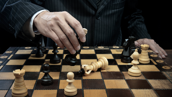 man in pinstriped suit winning chess match