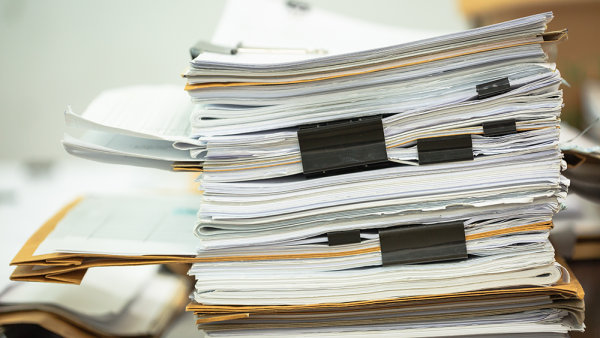 thick binders stacked on a desk