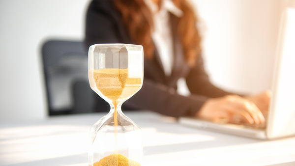 lawyer working on laptop with hourglass in the foreground