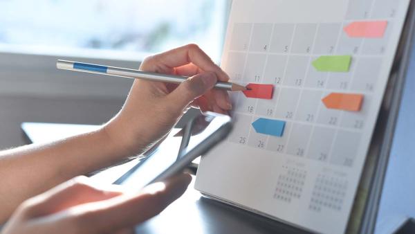 person using a calendar to mark important dates