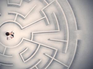 a lawyer standing at the center of a labyrinth, shot from overhead