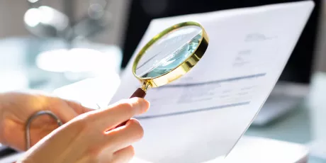 examing a document with a magnifying glass