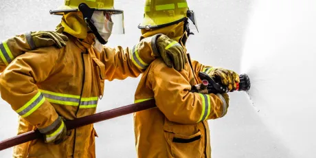team of firefighters directing fire hose